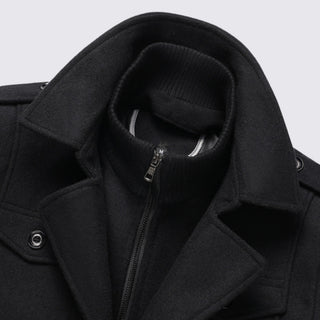 Close-up of a black coat with a zipper and collar detail on a light gray background