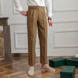 Person wearing beige trousers standing in a room with decorative elements.