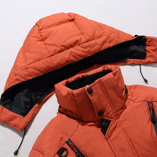 Close-up of an orange puffer jacket with a hood on a light gray background