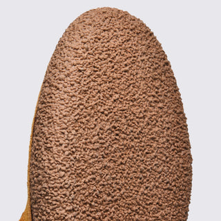 Close-up of a textured brown shoe sole on a light gray background