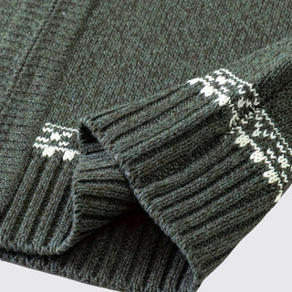 Dark gray ribbed sweater with white patterned cuffs on a light gray background