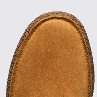 Close-up of a brown suede shoe sole on a light gray background