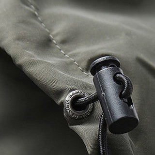 Close-up of a zipper on a green jacket with metal pull tab.