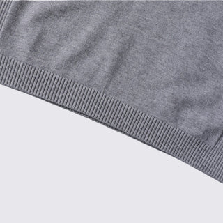 Close-up of a gray sweater with ribbed trim on a light gray background