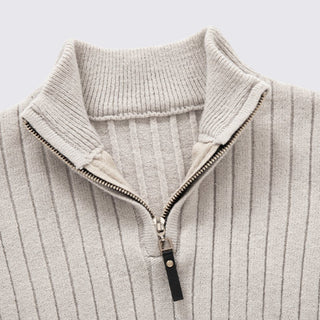 Close-up of a ribbed knit sweater with a zipper on a light gray background