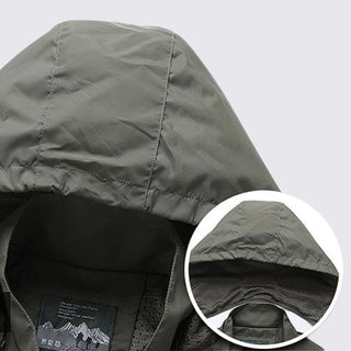 Close-up of a green jacket with a hood, showing texture and brand label.