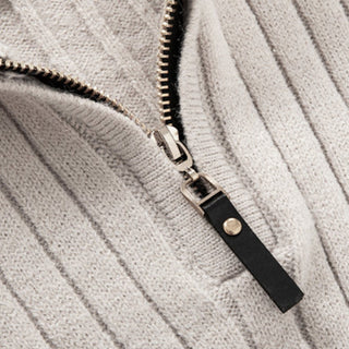 Close-up of a textured fabric with a zipper and leather pull tab.