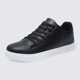 Black leather sneaker with white sole on a light gray background