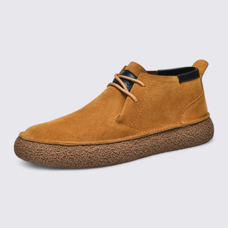 Brown suede shoe with a textured sole on a light gray background